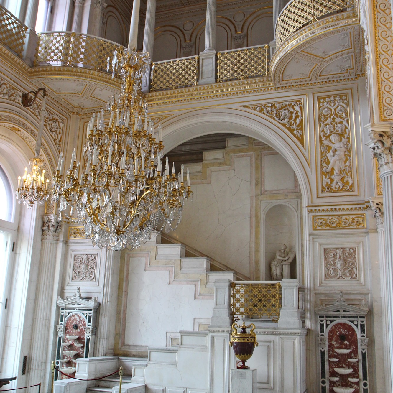 magnifique escalier blanc surplombé d'un lustre au musée de l'Ermitage
